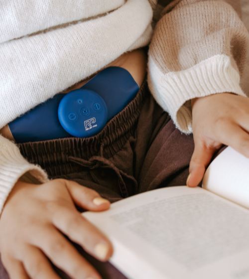 Relief Pro wearable TENS device shown under waistband.